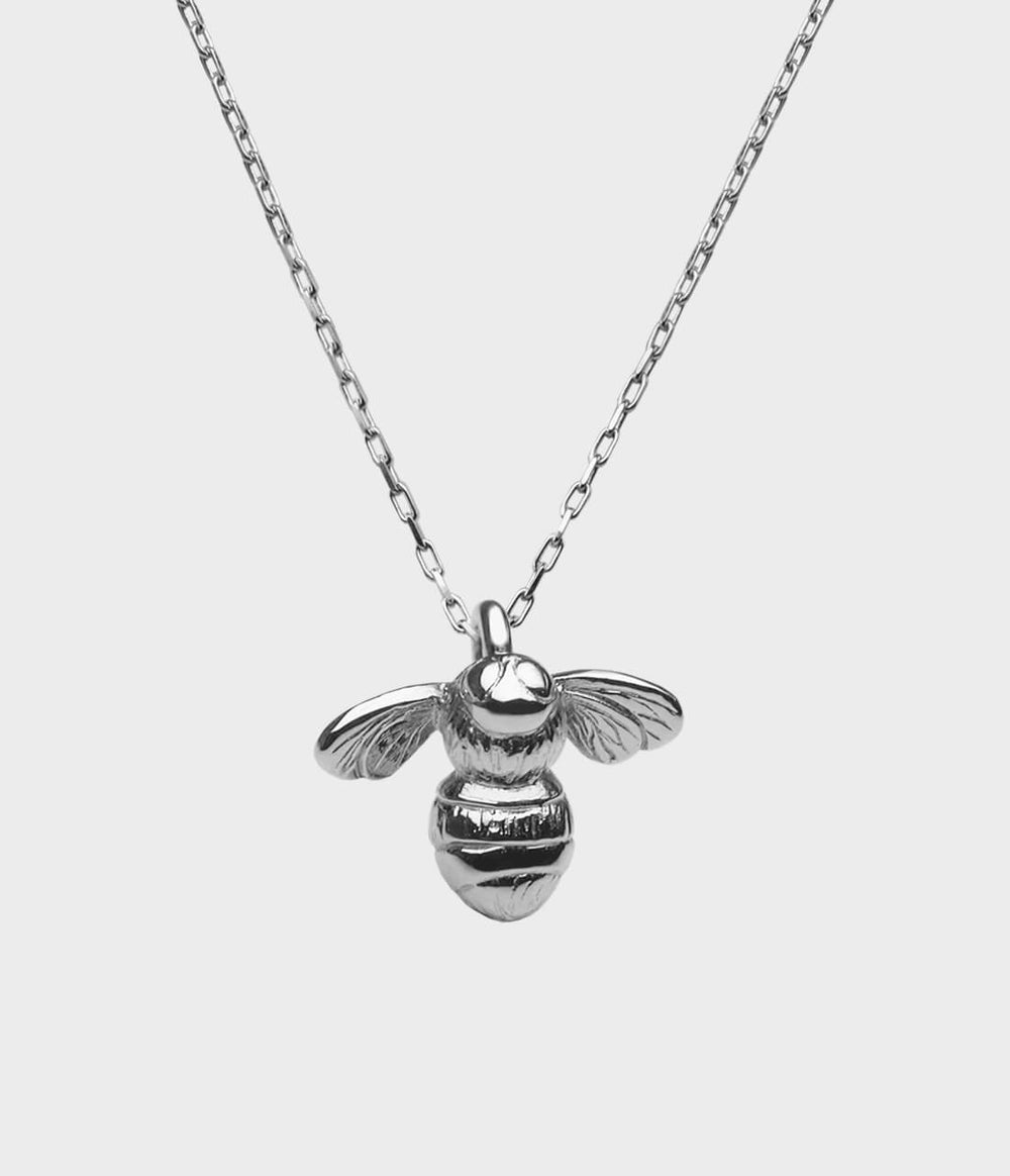 close up of the detail of a silver bumblebee necklace.