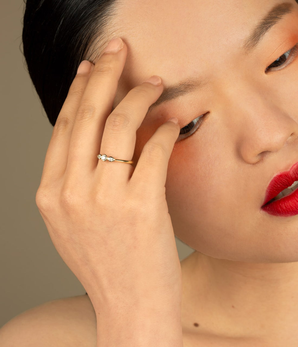 a girl in red lipsticj wearing a delicate angel engagement ring.